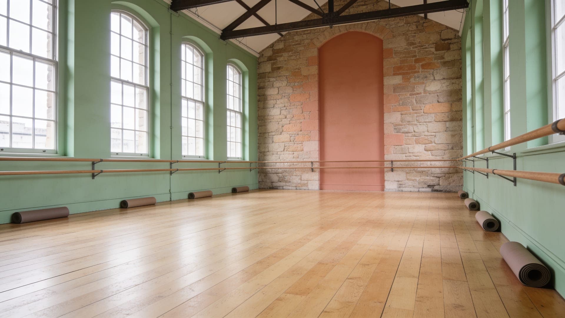 Soft daylight falling across a calm, open movement studio with a wood floor.